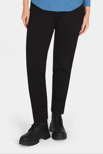 Woman wearing a blue sweater and black pants on a white background