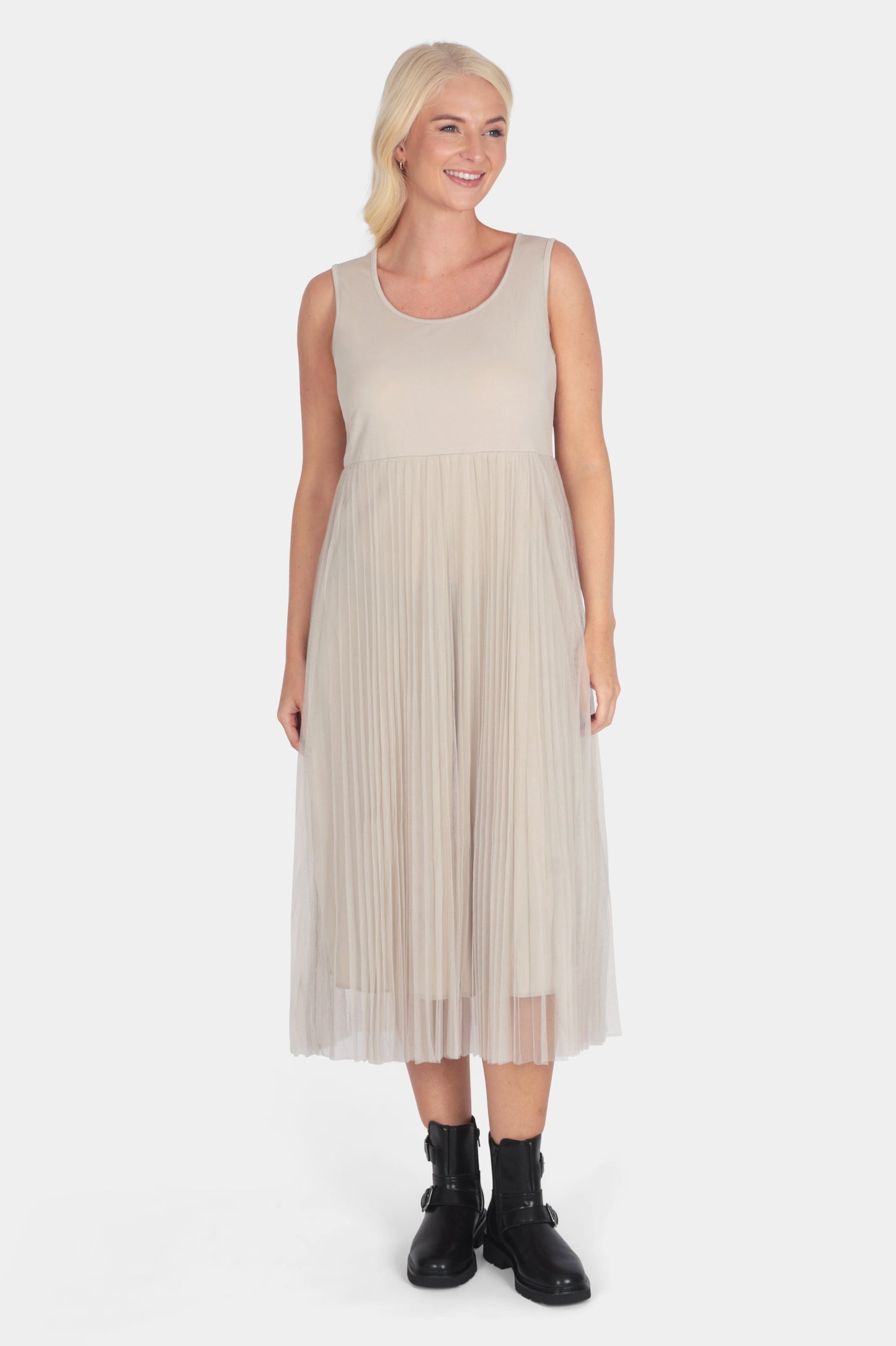 Woman wearing a beige pleated dress on a white background