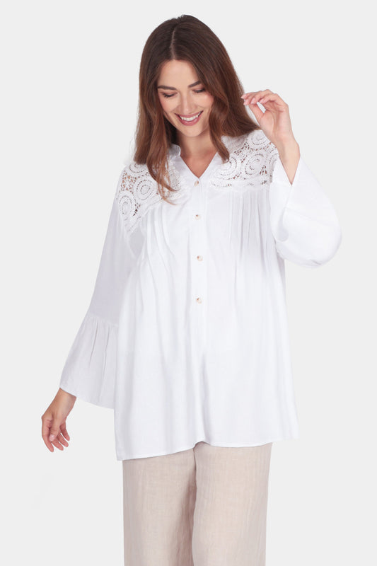 Woman wearing a white Crochet Detail Shirt with lace yoke, long flared sleeves, band collar, and button-up front.