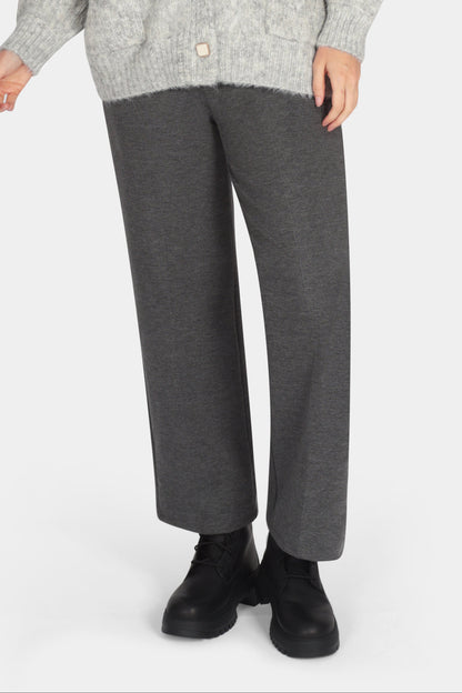 Woman wearing a gray cardigan and pants on a white background