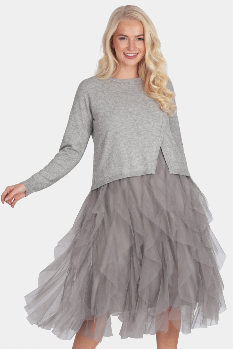 Woman wearing a gray sweater and tulle skirt on a white background
