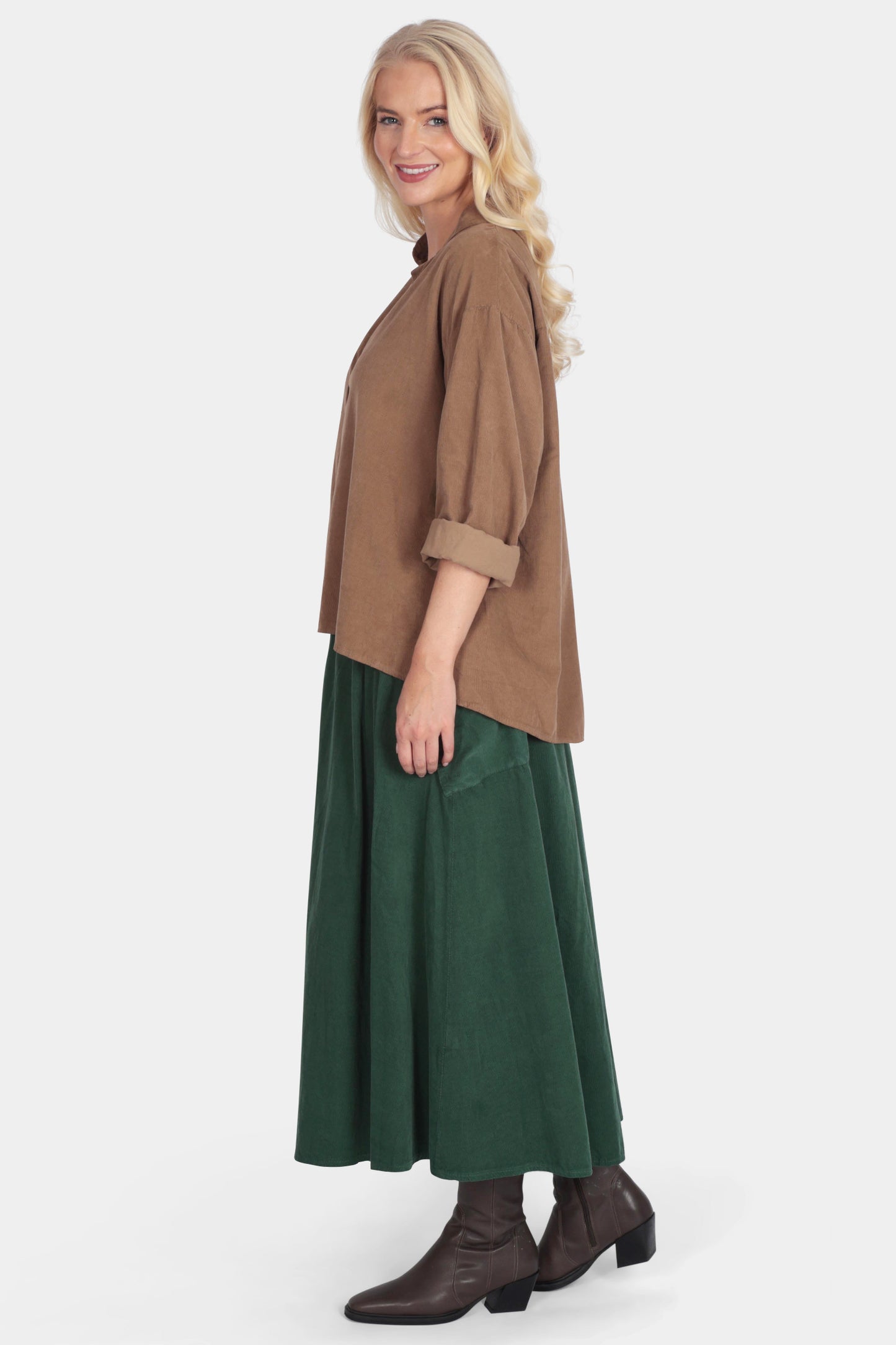 Woman wearing a brown shirt and green skirt on a white background