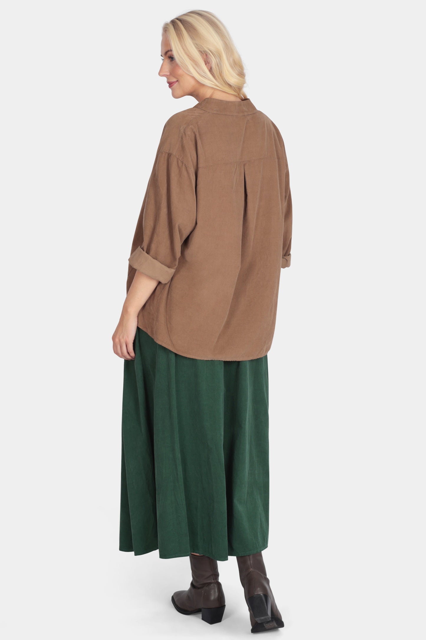 Woman wearing a brown shirt and green skirt on a white background
