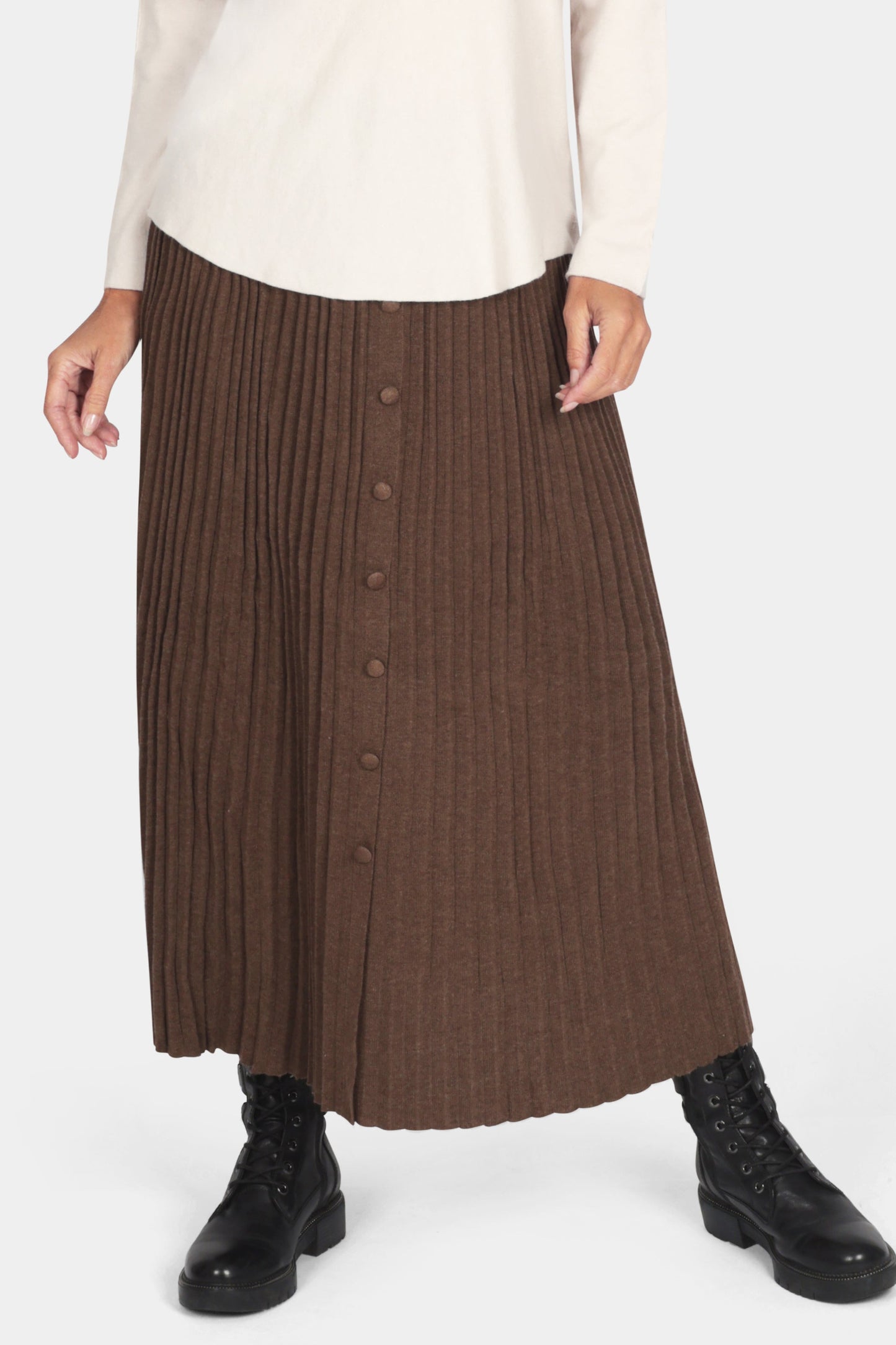Woman wearing a white top and brown pleated skirt on a white background