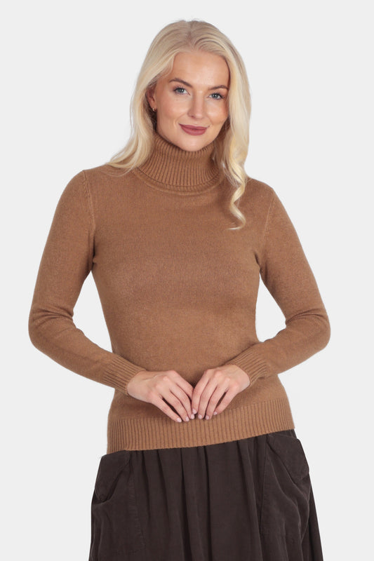 Woman wearing a brown turtleneck sweater and dark brown skirt on a white background