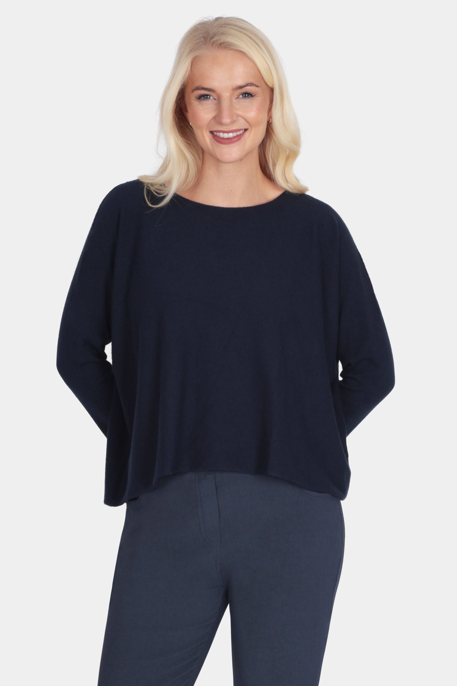 Woman wearing a navy blue outfit with white sneakers on a white background