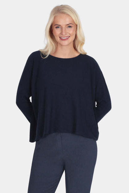 Woman wearing a navy blue outfit with white sneakers on a white background