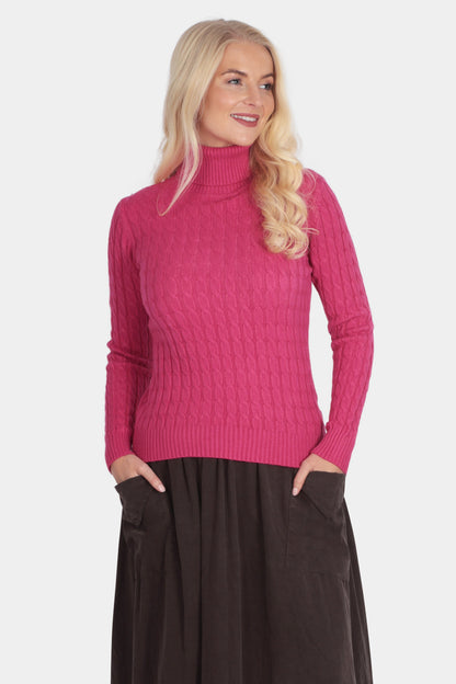 Woman wearing a pink sweater and brown skirt on a white background