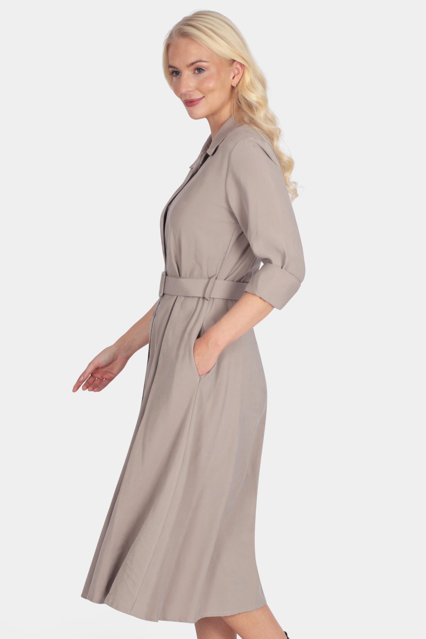 Woman wearing a beige dress with a belt on a white background