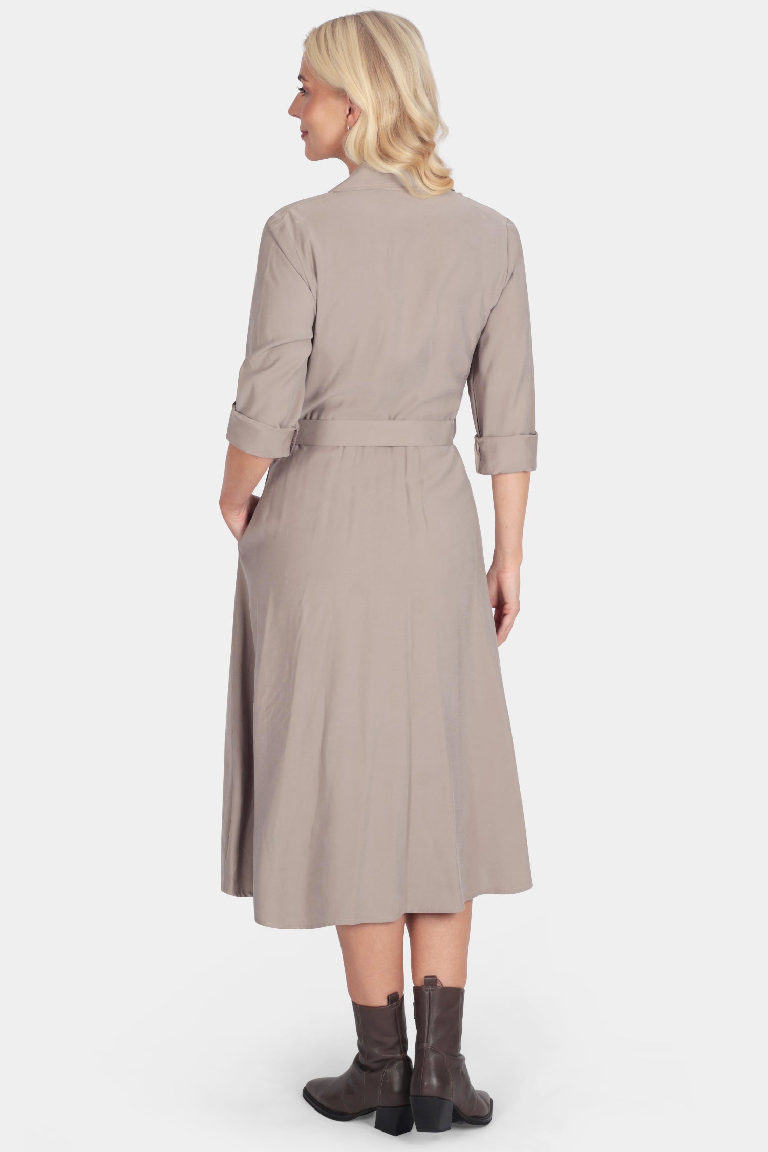 Woman wearing a beige dress with a belt on a white background