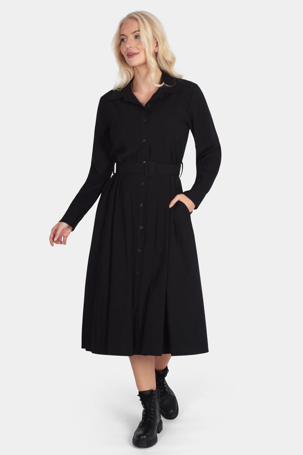 Woman wearing a black dress with long sleeves on a white background