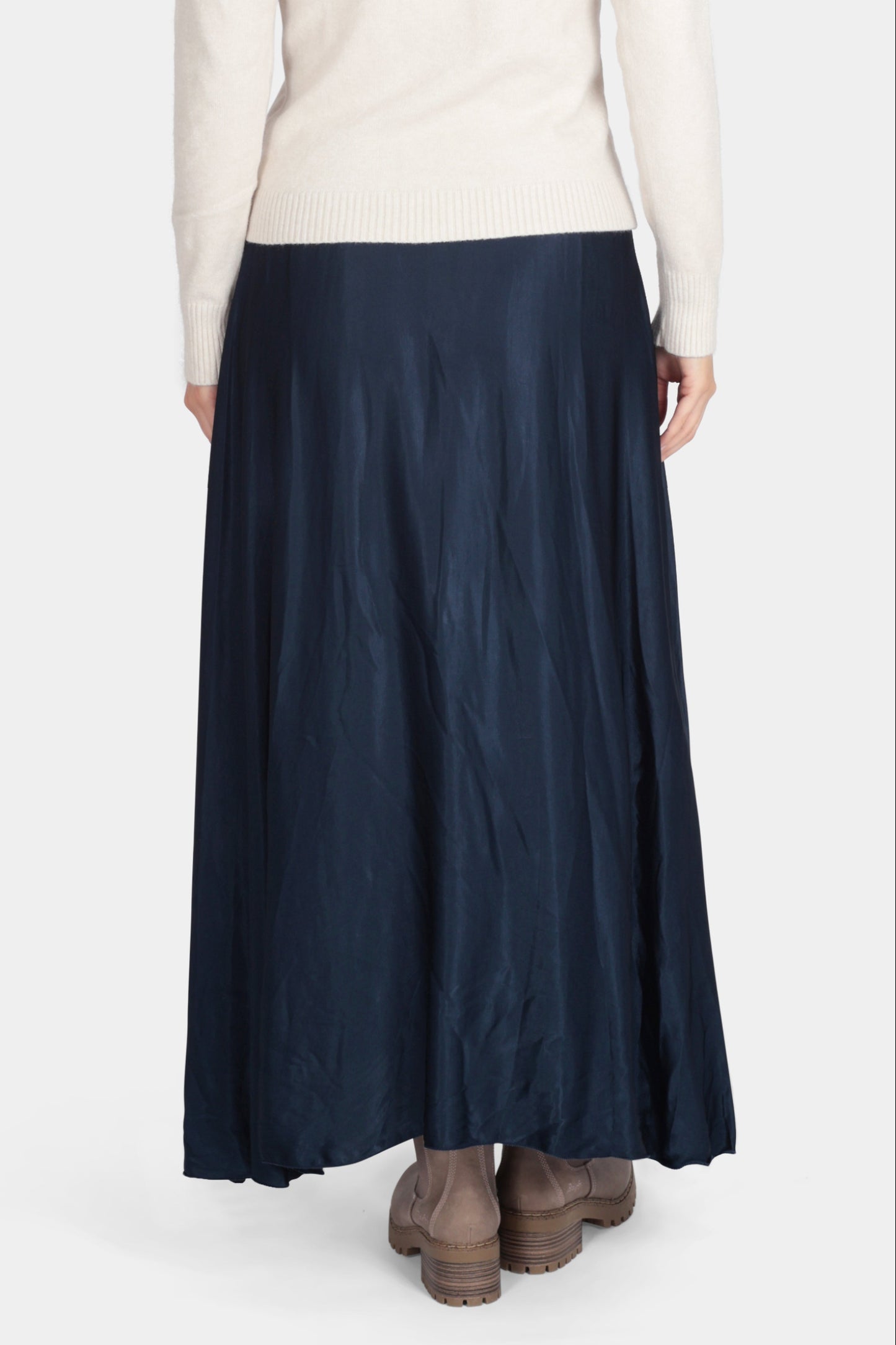 Person wearing a white shirt and navy skirt on a white background