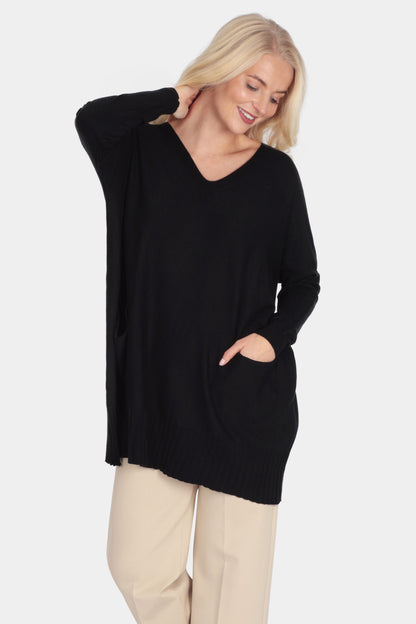 Woman wearing a black sweater and beige pants on a white background