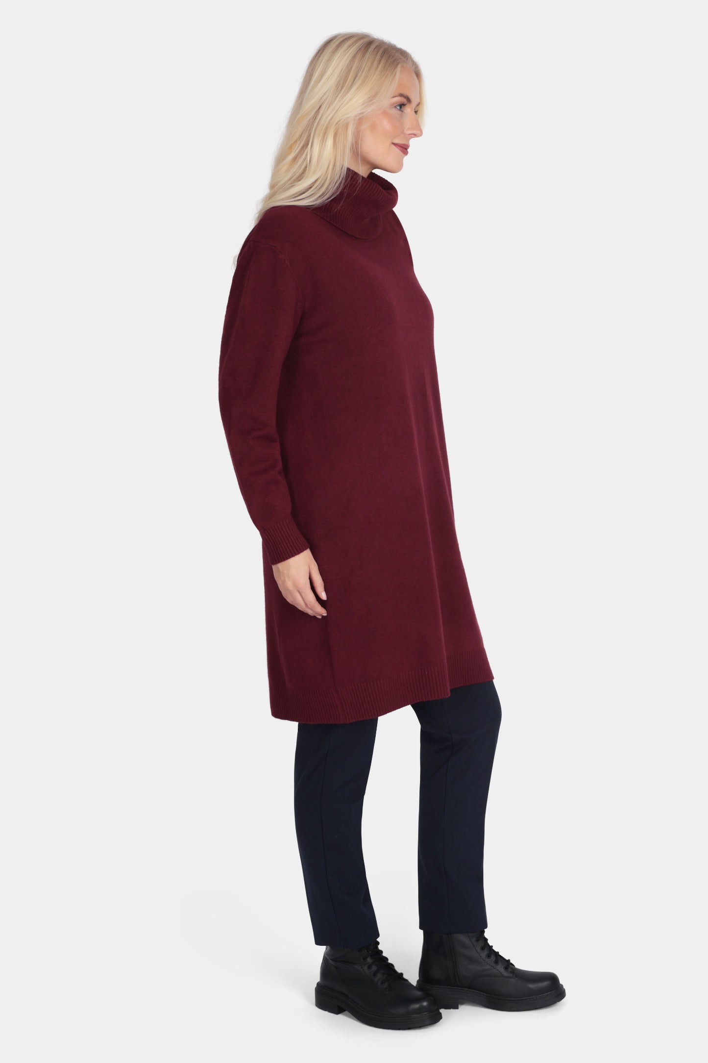 Woman wearing a burgundy long-sleeve dress on a white background