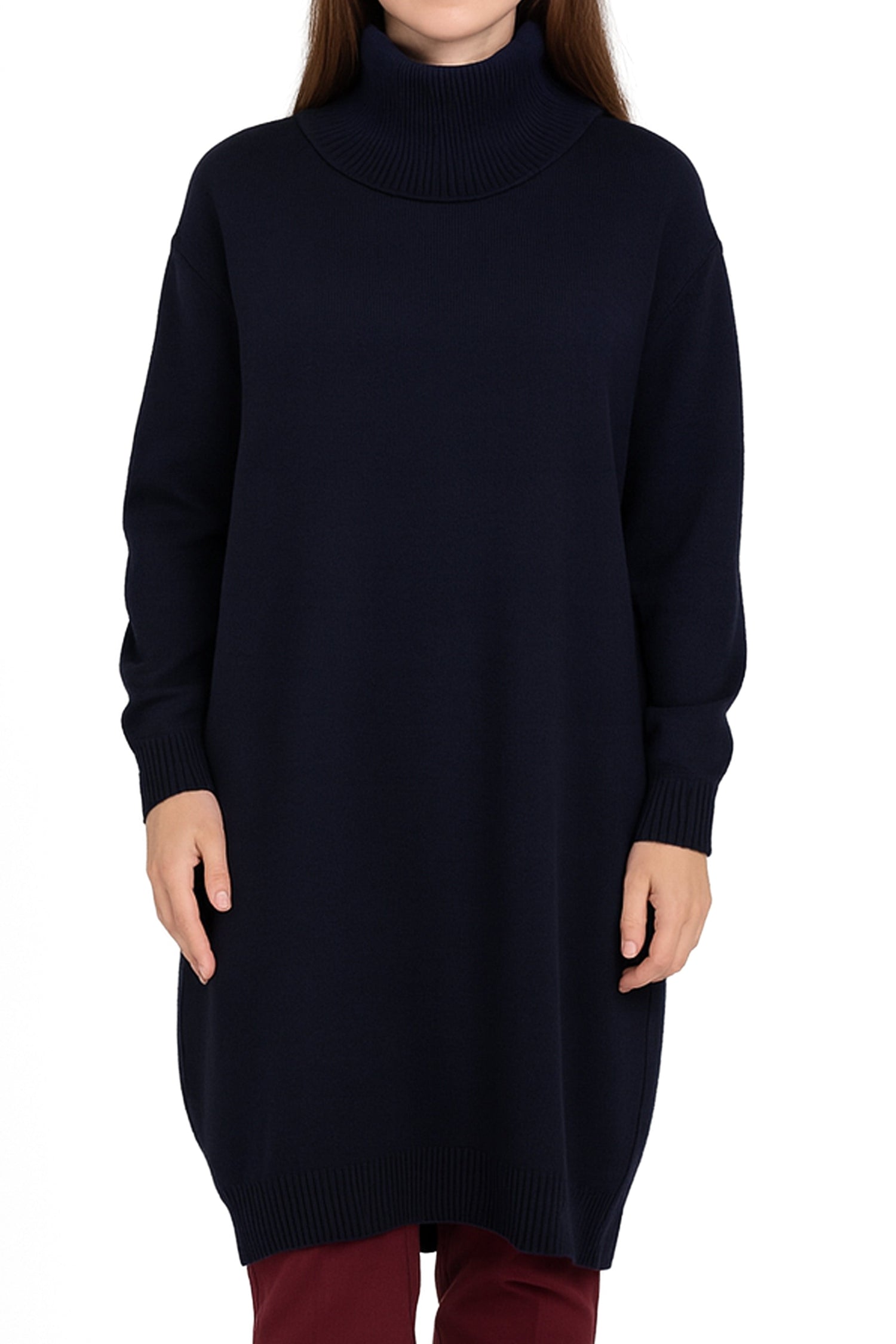 Woman wearing a long black sweater and red pants on a white background