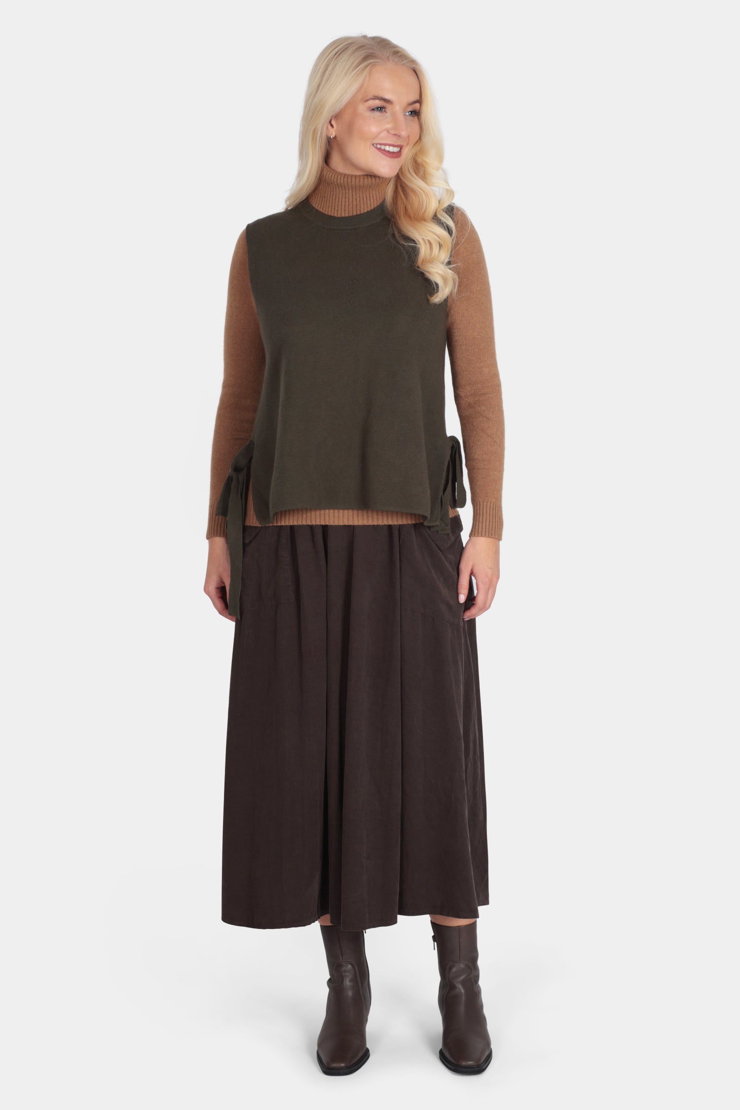 Woman wearing a brown top and dark brown skirt on a white background