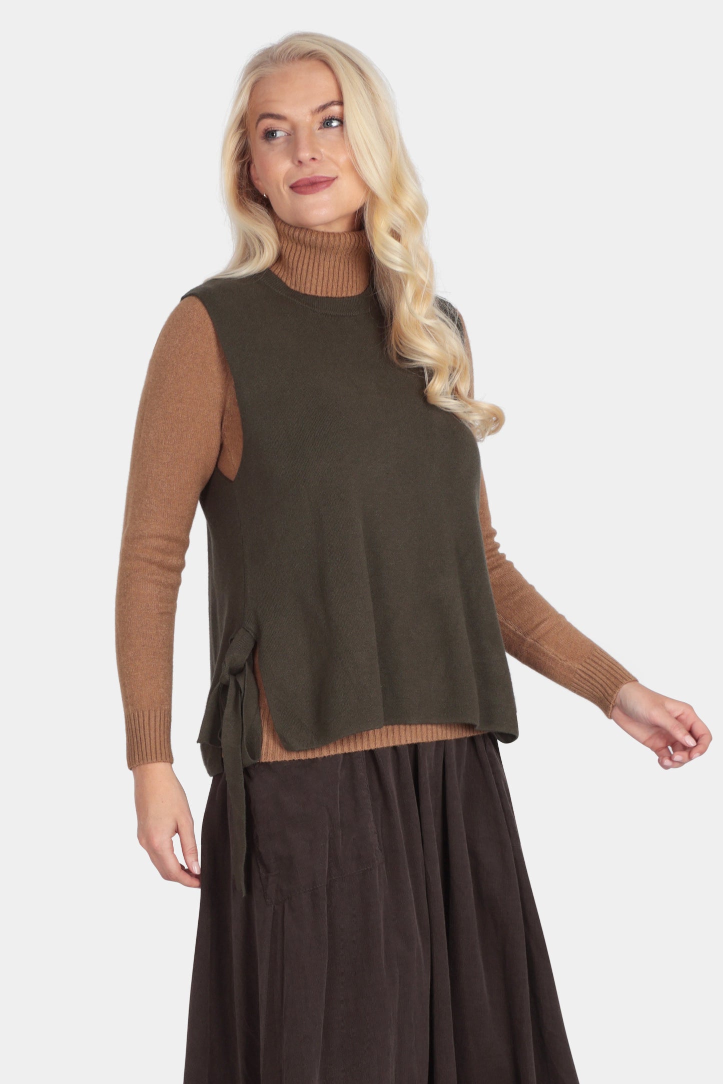 Woman wearing a brown sleeveless top and skirt set on a white background